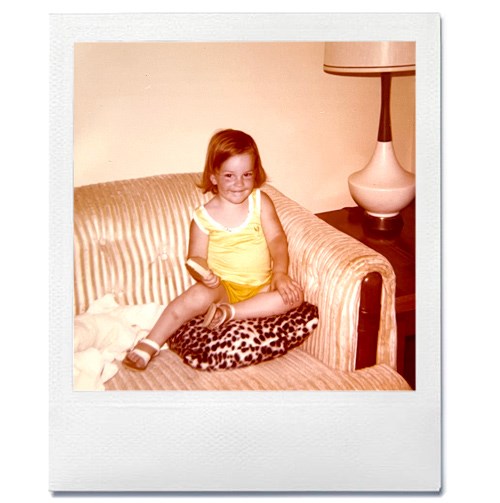 Polaroid of Tara as a young girl on a couch